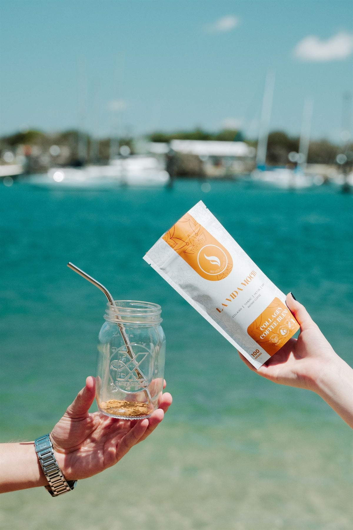 Brewdy collagen blend held over turquoise water